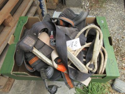 une boîte remplie de chaussures et d'autres objets posée par terre