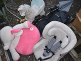 trois peluches posées par terre à côté d'un siège auto pour bébé
