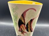 un vase jaune orné d'un poisson, posé sur une table