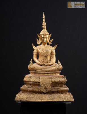 a gold statue of a person sitting on top of a table