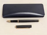 black leather case with a pen and pencil on a white surface