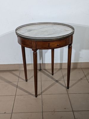 a small table with a marble top on a tiled floor