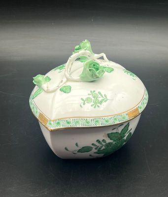an image of a green and white bowl with a lid on a table