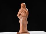 sculpture représentant une femme tenant un enfant dans ses bras, posée sur une surface blanche
