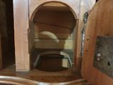 a wooden cabinet with a toilet in it on a wooden floor
