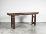 une vieille table en bois posée sur un sol en béton