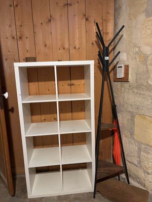 une bibliothèque blanche avec un porte-manteau à côté