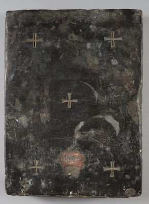 un vieux livre orné de croix, posé sur une table