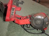 a picture of a red tool on a green surface