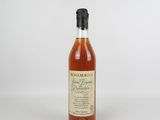 une bouteille de bourbon vide repose sur une surface blanche