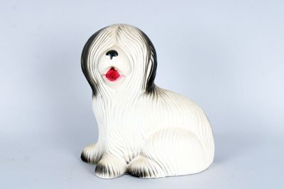 une figurine de chien blanche et noire posée sur une table