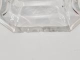 a clear glass ashtray on a white table