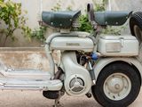 a white motor scooter parked on the side of the road