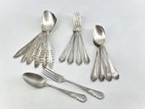 a lot of silver spoons and spoons on the table