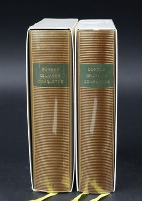 two books are sitting on a black surface with a yellow ribbon around them