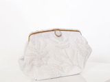 La pochette blanche est posée sur une table blanche.