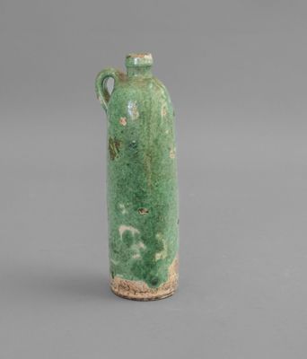 an image of a green vase with a handle on a gray surface