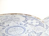 two blue and white plates with designs on them