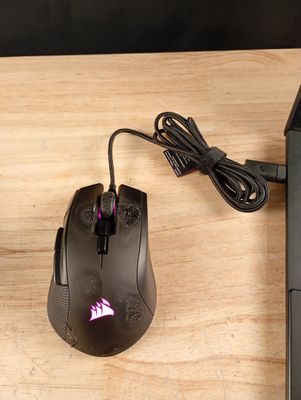 une souris d'ordinateur et un ordinateur portable posés sur une table en bois