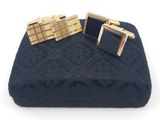 une paire de boutons de manchette noirs et dorés posés sur une couverture bleue