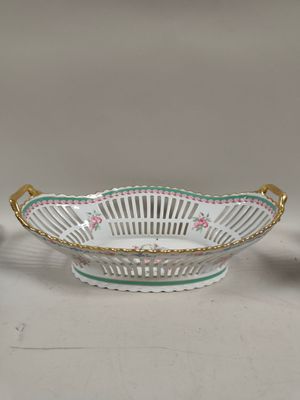 un bol blanc bordé d'or et un bol vert et blanc orné de fleurs roses