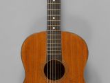une image représentant une guitare acoustique sur fond gris