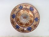 une assiette en or ornée d'un motif bleu et blanc