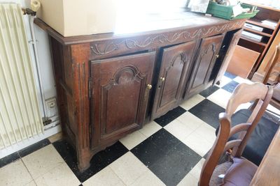 une armoire dans un coin d'une pièce dont le sol est en damier noir et blanc