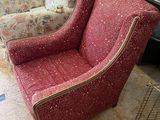 a red chair that is sitting in front of a fire place
