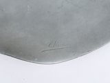 a silver plate with writing on it on a white surface