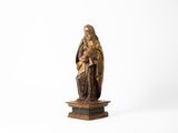 une vieille statue représentant une femme tenant un enfant dans ses bras, posée sur un socle