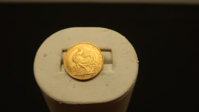 a gold coin sitting on top of a white object