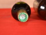 two bottles of wine sitting on a red cloth