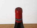 a bottle of wine sitting on a table next to a glass of wine