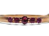 un gros plan d'une bague en or sertie de trois pierres violettes