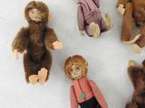 five stuffed animals sitting in a circle on a white surface