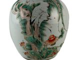 un vase blanc orné d'un oiseau et de fleurs