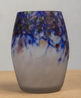 a blue and white vase sitting on a wooden table