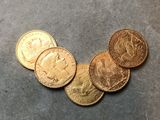 plusieurs pièces d'or posées les unes à côté des autres sur une table
