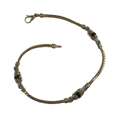 une image représentant un bracelet en or orné de pierres noires sur fond blanc