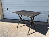 a small table with a laptop on it in front of a garage door