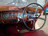 a man standing next to an old car with a steering wheel