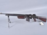 un pistolet ancien posé sur un trépied, sur une surface blanche