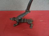 une petite statue représentant un lézard posée sur une table rouge