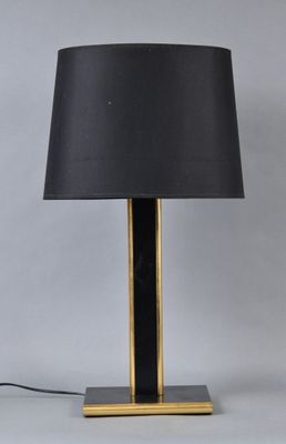 a black and gold table lamp with a black shade