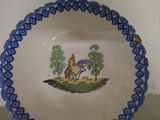 a blue and white plate with a picture of a man riding a horse