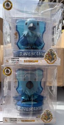 trois figurines Harry Potter dans leur emballage en plastique, posées sur une table