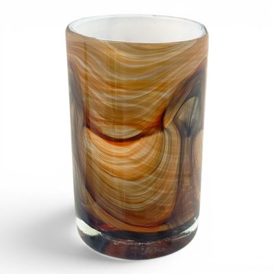 a close up of a glass with a brown swirl on it