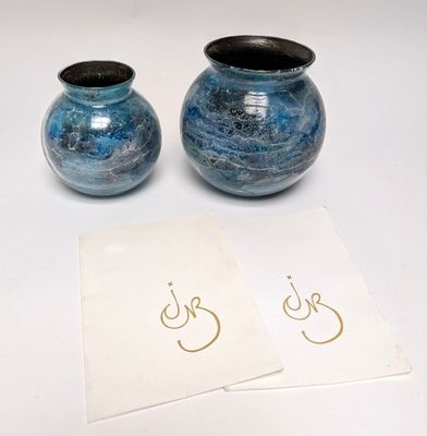 two blue vases sitting next to each other on a table