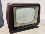 a small television sitting on a table with a white wall in the background